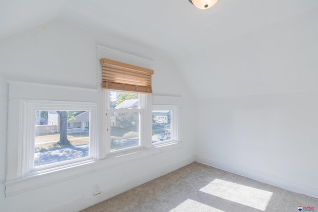 bonus room featuring vaulted ceiling and light colored carpet