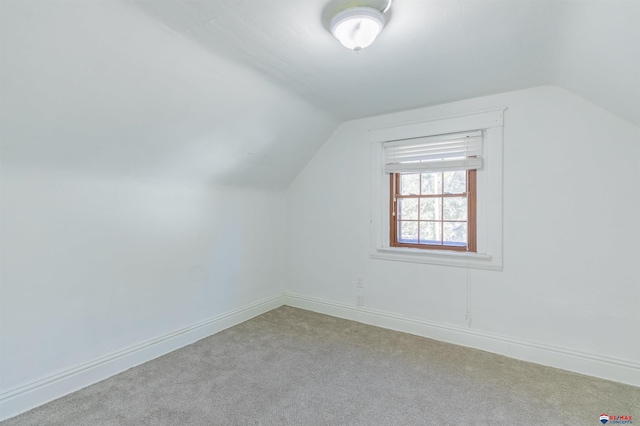 bonus room with light carpet and vaulted ceiling