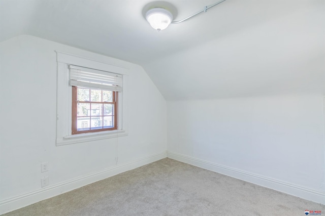 bonus room featuring light carpet and vaulted ceiling