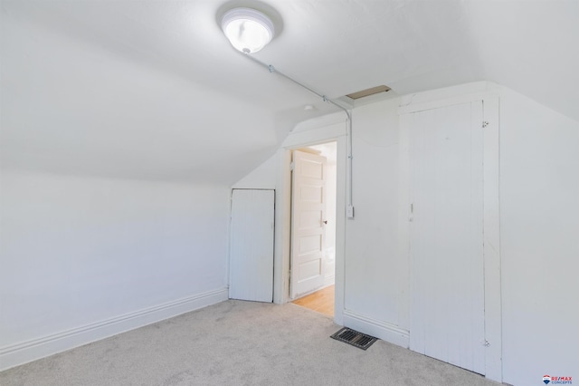 additional living space featuring light carpet and lofted ceiling