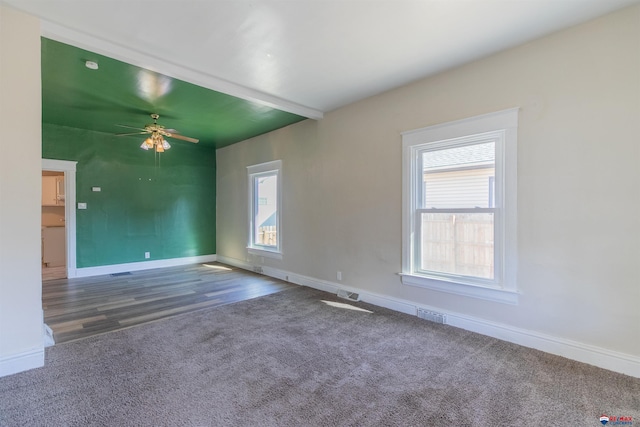 empty room featuring dark hardwood / wood-style floors, ceiling fan, and a wealth of natural light