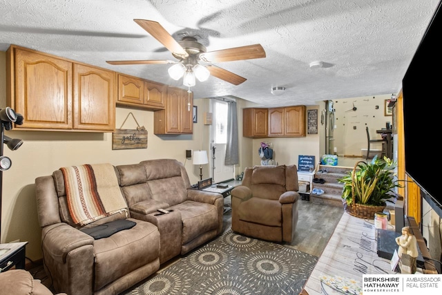 living room with ceiling fan, a textured ceiling, and hardwood / wood-style floors