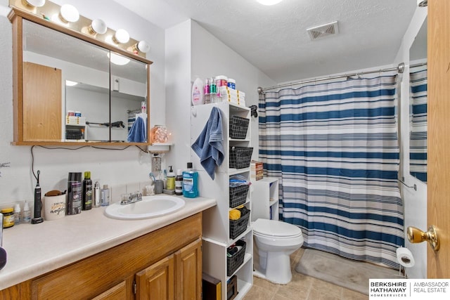 bathroom with vanity, curtained shower, a textured ceiling, and toilet