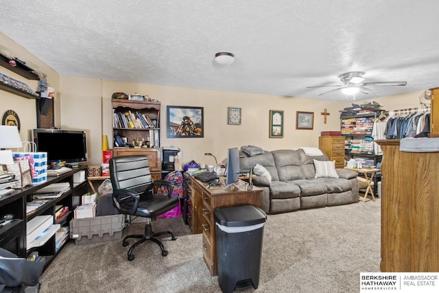 carpeted office space featuring ceiling fan and a textured ceiling