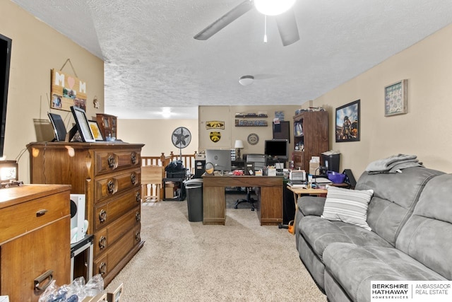 office featuring light carpet, a textured ceiling, and ceiling fan