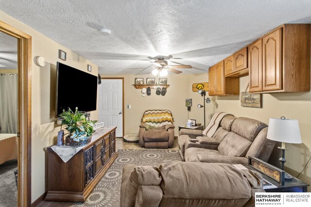 living room featuring a textured ceiling and ceiling fan