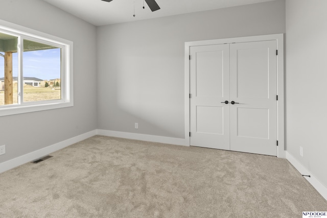 unfurnished bedroom with a closet, carpet, visible vents, and baseboards