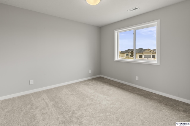 spare room with visible vents, baseboards, and carpet