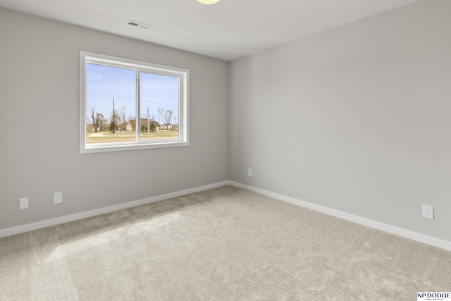 carpeted spare room featuring visible vents and baseboards