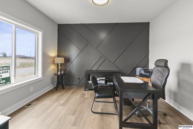 office with light wood-style flooring, baseboards, and visible vents