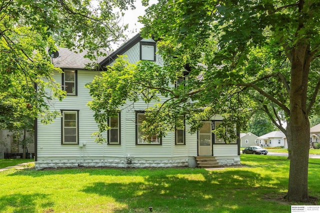 rear view of property featuring a lawn