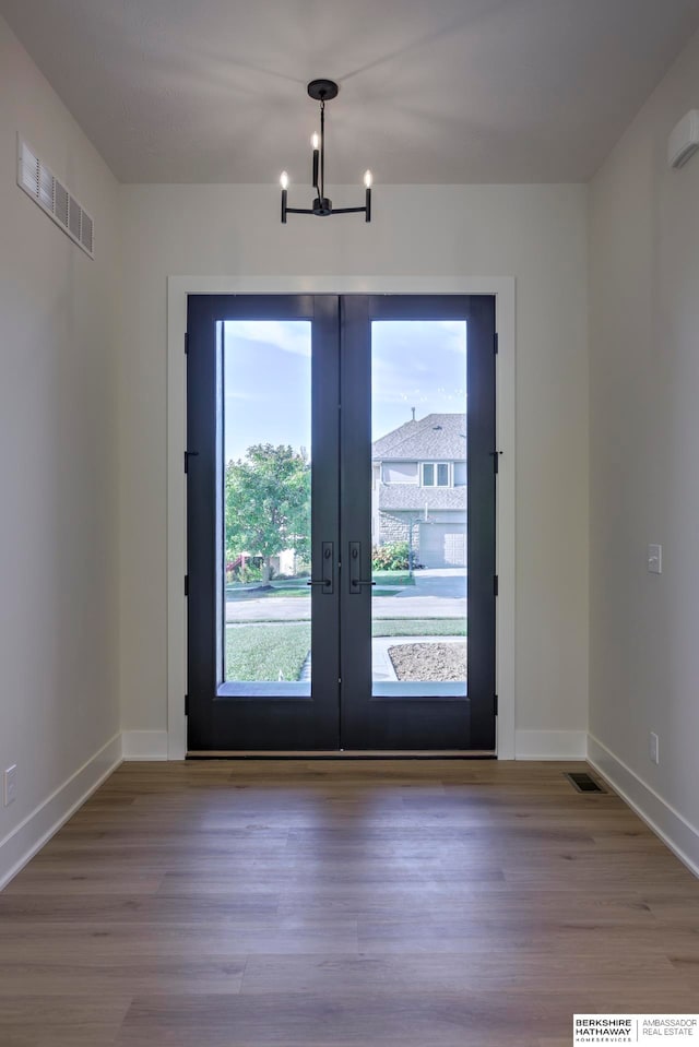 doorway to outside featuring a chandelier, french doors, and light hardwood / wood-style floors