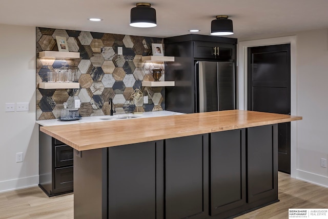 kitchen with light hardwood / wood-style flooring, butcher block counters, and sink