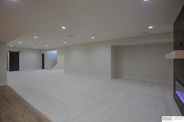 basement with light carpet and a barn door