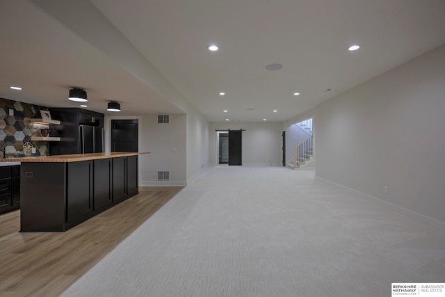 kitchen with a kitchen bar and light wood-type flooring