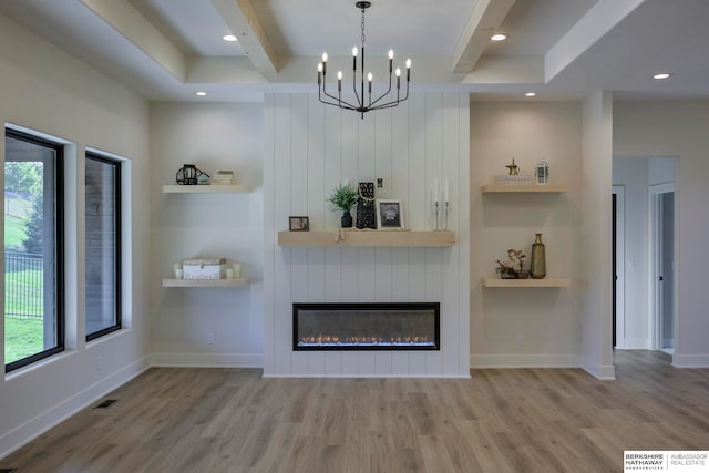 unfurnished living room with beamed ceiling, a notable chandelier, wood-type flooring, and a healthy amount of sunlight