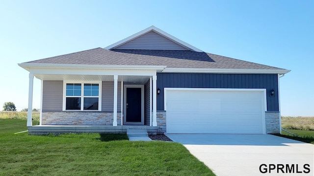 view of front of property with covered porch, a garage, and a front lawn