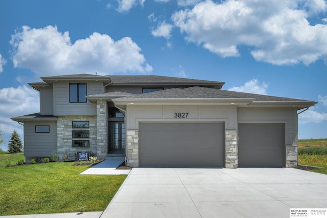 prairie-style home with a front yard and a garage