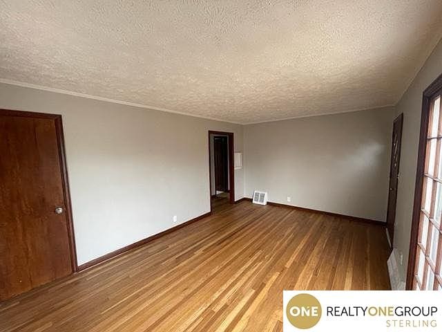 unfurnished room featuring a textured ceiling and hardwood / wood-style flooring