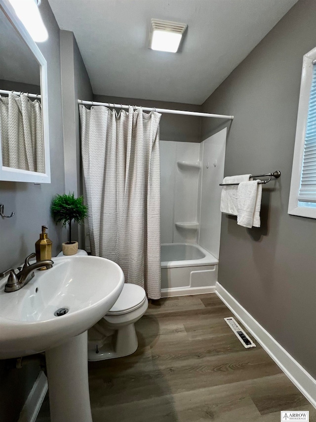 bathroom with shower / bath combination with curtain, toilet, and hardwood / wood-style flooring