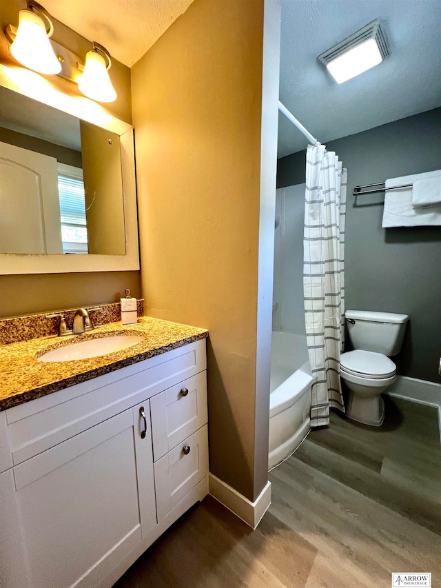 full bathroom featuring vanity, wood-type flooring, shower / tub combo with curtain, and toilet