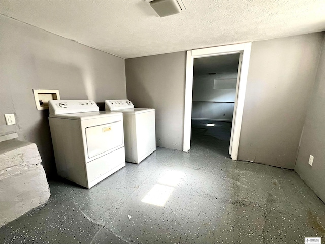 laundry area featuring washer and dryer and a textured ceiling