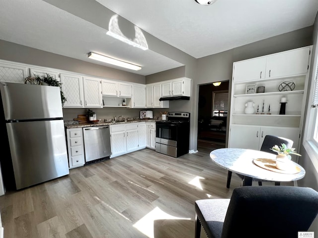 kitchen featuring white cabinets, stainless steel appliances, sink, and light wood-type flooring