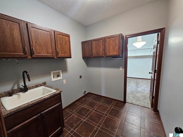 laundry area with washer hookup, hookup for an electric dryer, sink, cabinets, and a textured ceiling