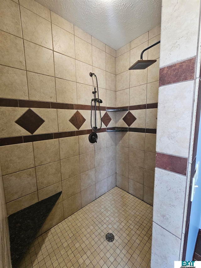 bathroom featuring a textured ceiling and tiled shower