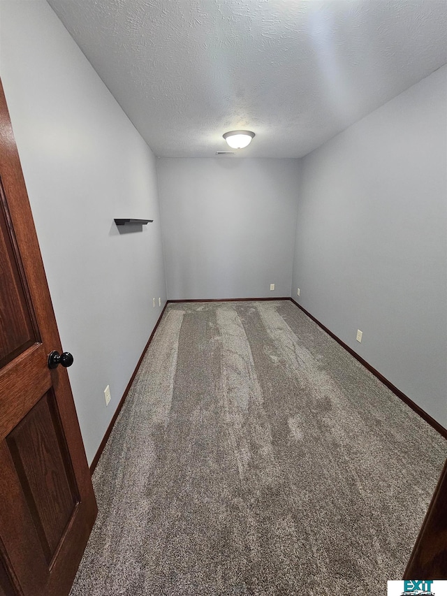 spare room with a textured ceiling and carpet floors