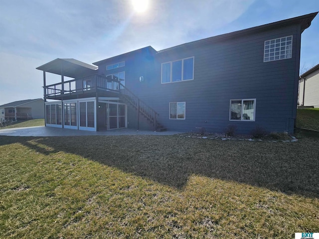 rear view of property featuring a patio, a wooden deck, a sunroom, and a lawn