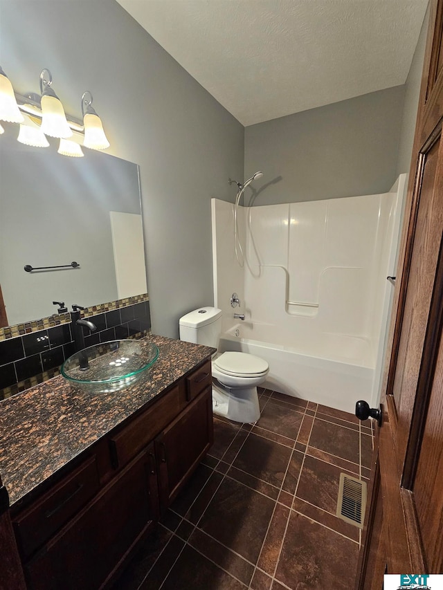 full bathroom with a textured ceiling, toilet, vanity, tile patterned floors, and shower / bath combination