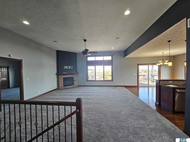 unfurnished living room featuring dark wood-type flooring, a textured ceiling, a wealth of natural light, and a fireplace