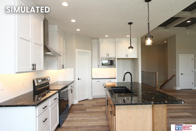 kitchen featuring a center island with sink, pendant lighting, white cabinetry, and appliances with stainless steel finishes