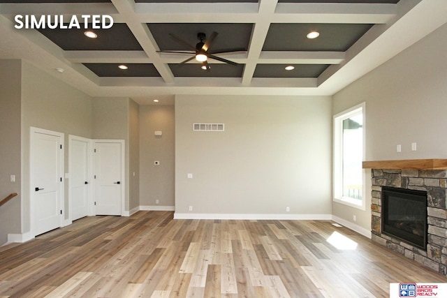 unfurnished living room with coffered ceiling, hardwood / wood-style flooring, ceiling fan, a fireplace, and beam ceiling