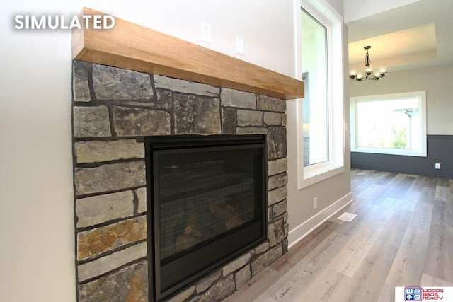 room details featuring a fireplace, hardwood / wood-style floors, and an inviting chandelier