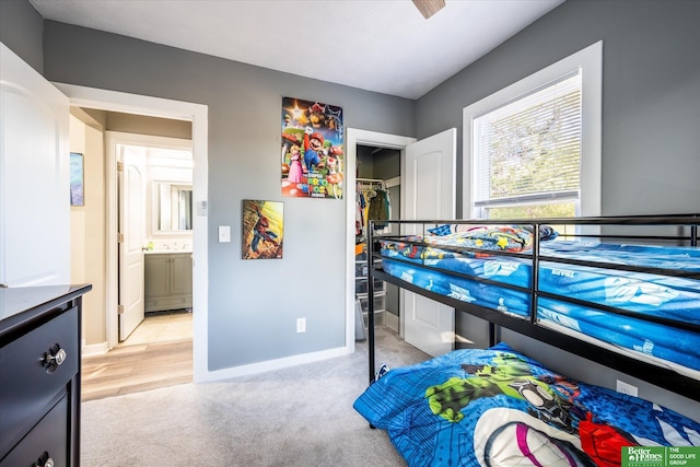 carpeted bedroom featuring ensuite bathroom and a closet