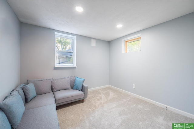 living area with light carpet and a healthy amount of sunlight