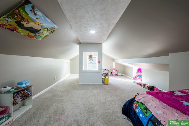 bedroom featuring a textured ceiling, vaulted ceiling, and carpet flooring