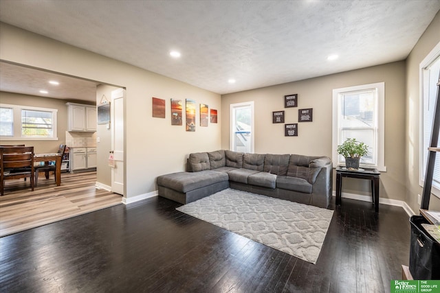 living room featuring dark wood-type flooring and a textured ceiling