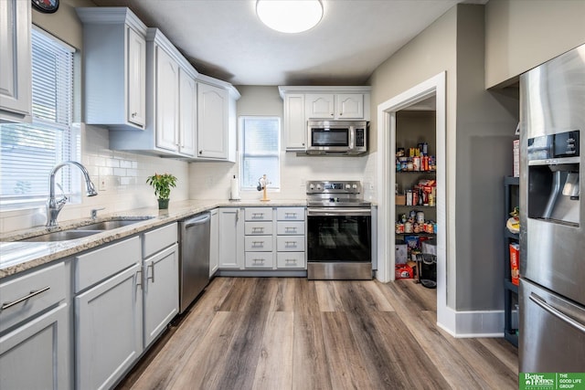 kitchen featuring sink, appliances with stainless steel finishes, dark hardwood / wood-style floors, and plenty of natural light