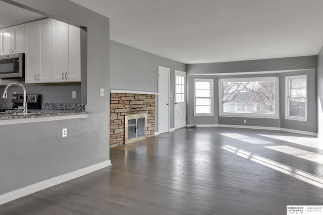 unfurnished living room featuring a fireplace and dark hardwood / wood-style flooring