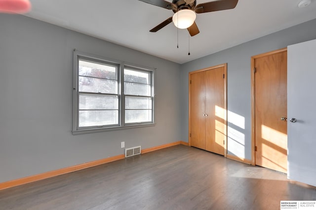 spare room with ceiling fan and dark hardwood / wood-style flooring