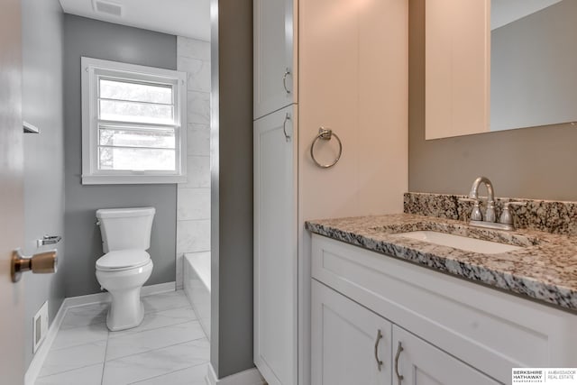 bathroom featuring vanity, a tub, and toilet