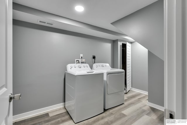 laundry room featuring light hardwood / wood-style floors and washing machine and clothes dryer