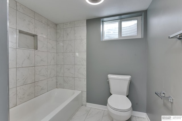 bathroom featuring tiled shower / bath and toilet