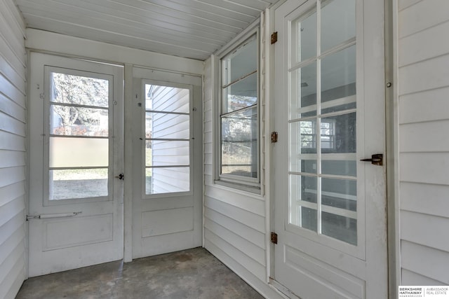 doorway to outside featuring wooden walls