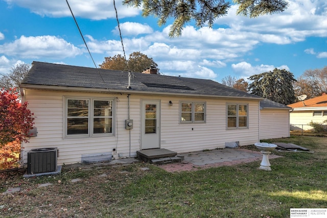 rear view of property featuring a yard, a patio area, and central air condition unit