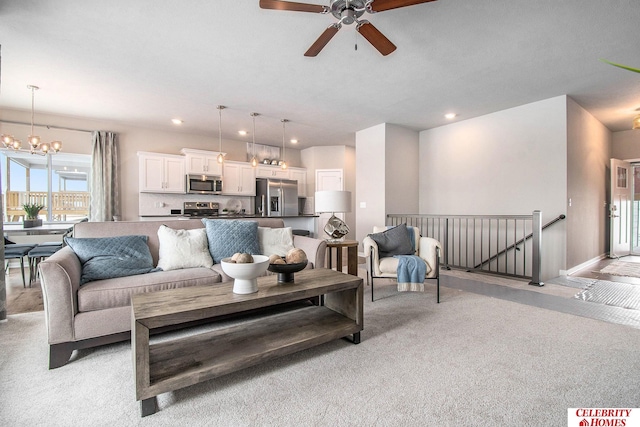 living room featuring light carpet and ceiling fan with notable chandelier