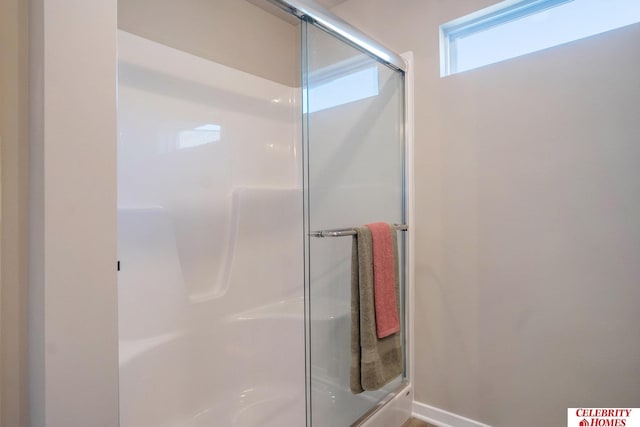 bathroom featuring a shower with shower door